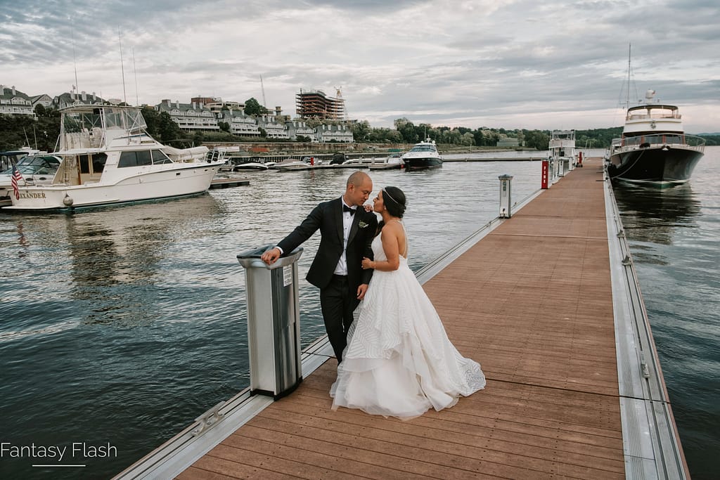 Bride posing with Groom on waterfront dock