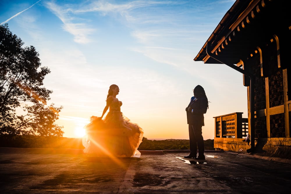 bride and groom dancing on patio with stunning sunset as a backdrop