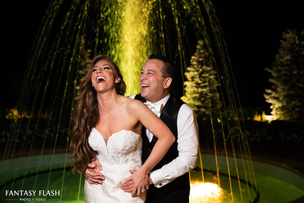 a bride and groom hugging at the fountain
